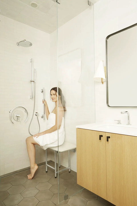 Woman in bathroom using 18 Inch Decorative Oval Wall Mount Grab Bar With Concealed Flanges For ADA Safety And Solid Grip 1.5 Inch Diameter