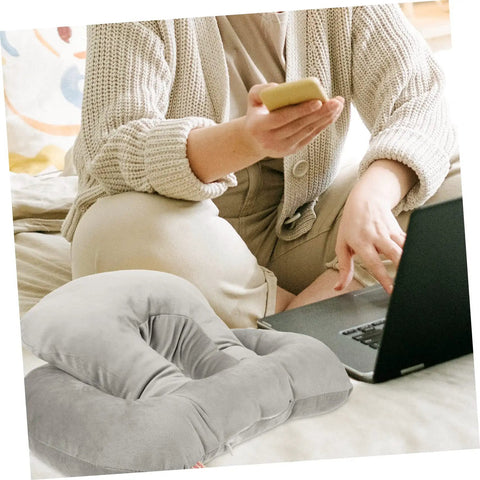 Portable Ergonomic Nap Pillow For Office And School, Face Down Sleep Cushion In Gray with plush material on a bed