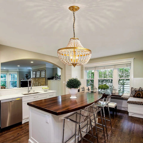 Three Light Boho Wood Beaded Gold Chandelier for Rustic Farmhouse Style Pendant Light Fixture illuminating a cozy kitchen dining area