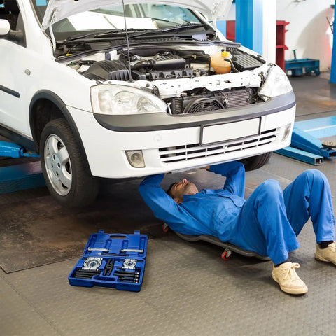 Professional Grade 14 Piece Automotive Bearing Puller Kit With Dual Disc Separator Aid To Remove Bearings Safely For Cars Or Motorcycles Great For Wrenching Fans Who Want Fast Results Using A Killer Puller Kit For Trucks And Bikes. blue case open beside mechanic under white car