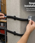 Hands installing the High Flex Corrugated Cable Conduit, 51 Mm Heavy Duty Wire Raceway With Galvanized Steel Core, 20 Meter Roll.