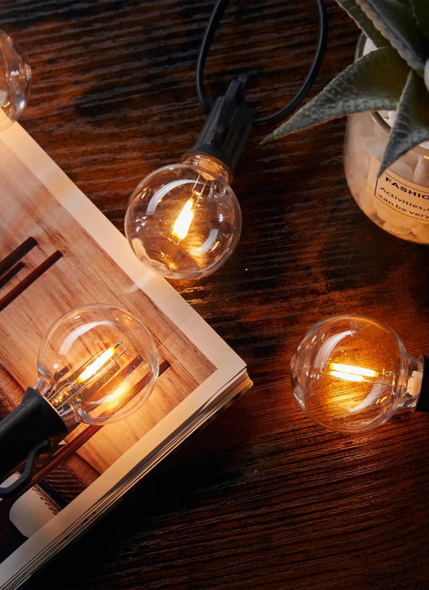 G40 LED Replacement Bulbs 25 Pack, E12 Base, 2200K Warm White, Shatterproof And Waterproof, glowing warmly on rustic table