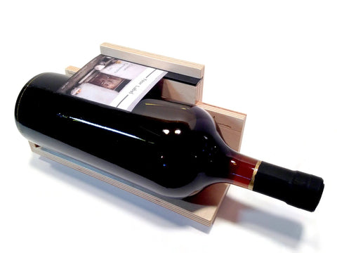 Level Up Your Sticker Game With This High Boy Bottle Alignment Jig That Nails It On Large Jars Sized From Three Half To Four Half Inches Easy Peasy For Sellers Demanding Flawless Labels Hit Perfect Every Single Time. Brown wood jig with wine bottle and label positioned for alignment.