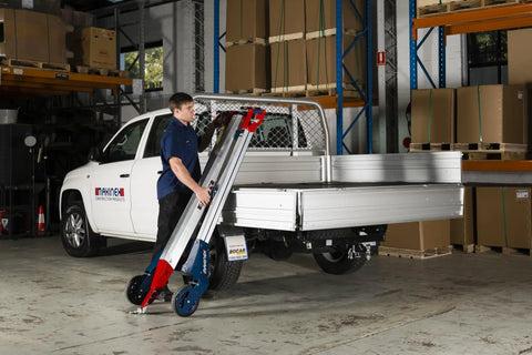 Worker using Powered Hand Truck Lift System With Hook, 309 Lb Lift Capacity, in warehouse near vehicle