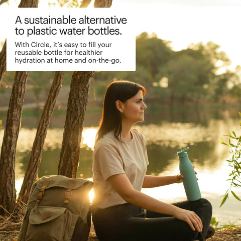 Woman outdoors holding a blue reusable bottle by a lake, Circle Under Sink Reverse Osmosis Membrane Replacement For Clean Water, Pro Grade WQA Certified, Reduces Fluoride Arsenic Heavy Metals, Cysts And Industrial Chemicals, Lasts Up To 24 Months.