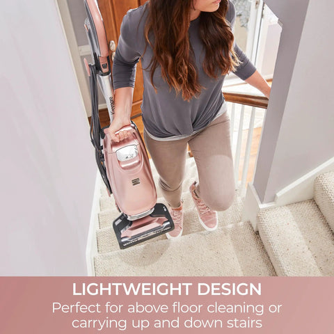 Woman using Kenmore Intuition Bagged Upright Vacuum With Hair Eliminator Brushroll on stairs for easy cleaning.