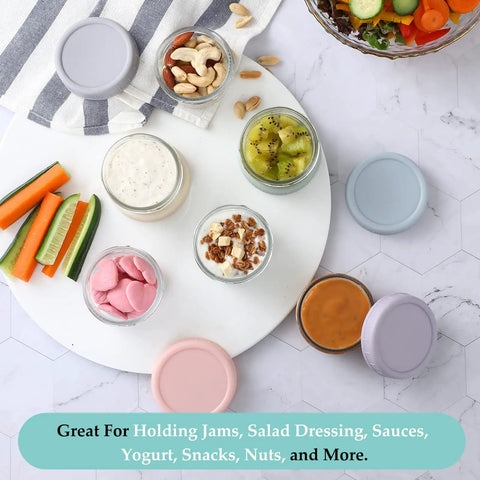 Top view of Six Pack 2.7 Oz Glass Salad Dressing Containers With Lids Leakproof Dipping Sauce Cups For Lunch Or Work Or Travel Reusable Small Condiment Jars BPA Free Dishwasher Safe Grab And Go Storage filled with various foods.