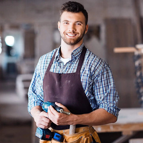 Person holding a drill inside a workshop.
