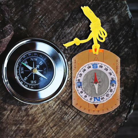 Orienteering Compass For Hiking And Camping With Lanyard Multifunction Navigation Tool Lightweight Portable Trail Backpacking Compass In Orange For Trekking Travel Outdoor Adventure And Backcountry Use next to circular compass on wooden surface