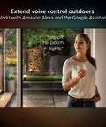Woman using voice control for Impress Outdoor Smart Wall Light With Color Ambiance LED, 16W Black Finish, Weatherproof, Color Changing Lamp For Patio Porch Entry