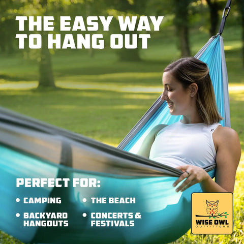 Woman enjoying a day in a blue hammock, outdoor setting, promoting versatility for camping, beach, backyard, and festivals.