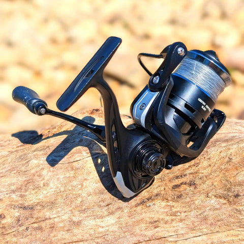 Loaded Spinning Reel With 10lb Braided Line, Carbon Disc Drag, 5.2 To 1 Gear, 7 Plus 1 Stainless Bearings on wooden surface