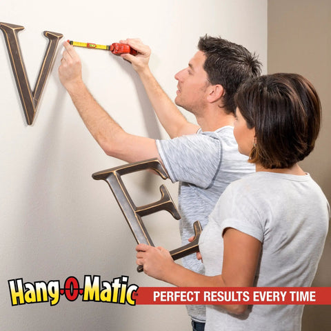 Two people using All In One Picture Hanging Tool For Quick Easy Leveling And Marking On The Wall To Hang Pictures Mirrors TVs And Shelves