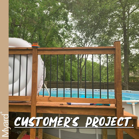 Customer's deck with 32 Inch Hollow Round Iron Deck Balusters 25 Pack Matte Black For Deck Railing Porch Staircase Banister Balustrade Tough As Nails Outdoor Ready Powder Coated AAMA 2604 Durable Finish, featuring a pool in the background.