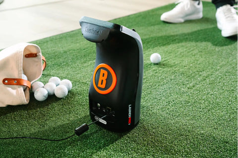 Launch Pro I Circle B Edition Golf Launch Monitor Bundle With Course GPS Overview on turf with golf balls and bag