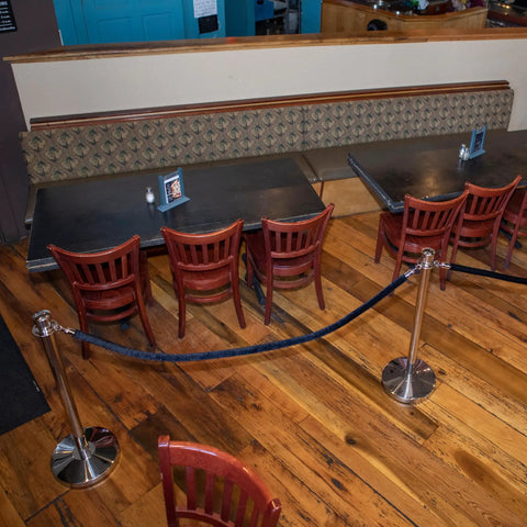 U2140 Premier Chrome Post And Black Velvet Rope Crowd Control Stanchions set around restaurant seating area