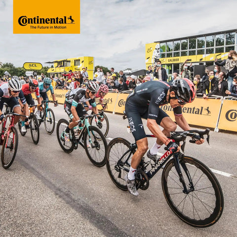 Cyclists racing in a professional road bike event sponsored by Continental, showcasing competition and high-performance bicycles.