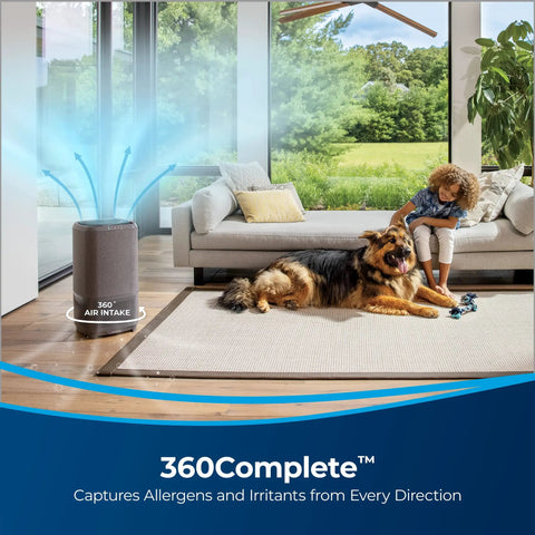 Room with air purifier showing 360 air intake, child playing with dog, modern interior, large windows, outdoor view.
