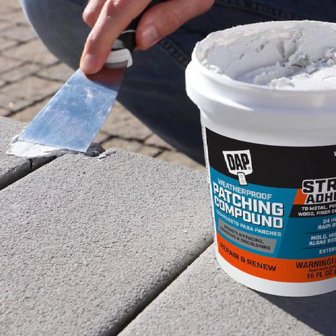 Applying Weatherproof Patching Compound 16oz White For Drywall And Masonry Repairs to outdoor masonry surface with spatula