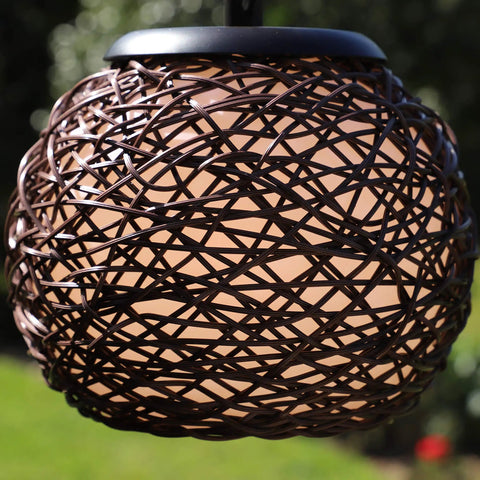 Close-up of woven rattan shade on Castillo Outdoor Floor Lamp With Oil Rubbed Bronze Highlight Finish in backyard.