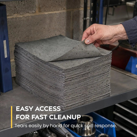 Heavy Duty Universal Absorbent Pads 10 X 13 Inch 100 Pack stacked on a workbench for easy access and quick cleanup.