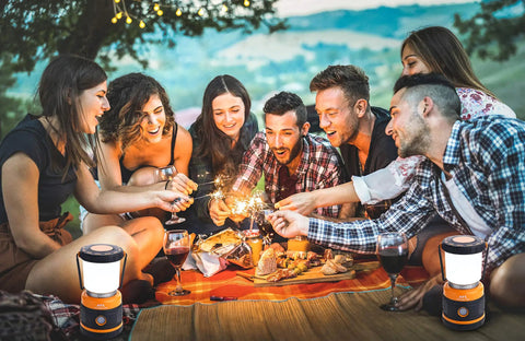 Group enjoying a picnic with Bright 1800 Lumen Go-To Camping Lantern With Four Lighting Modes for outdoor and survival use