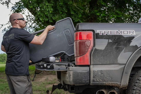 Person loading Stable Table Lite With Weatherproof Tabletop And Ambidextrous Seat into truck