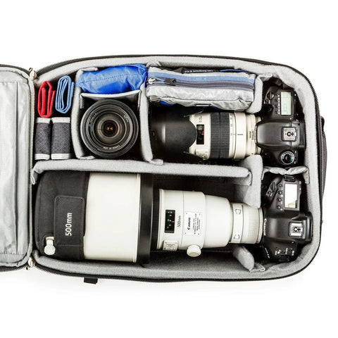 Interior of Airport Accelerator Camera Backpack for Travel Photographers Fits Two Gripped DSLRs With 600mm F4 Or 500mm F4 Attached 17 Inch Laptop and 10 Inch Tablet Built For Carry On Convenience And Everyday Rugged Use, showing organized compartments with lenses.