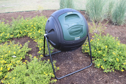 Ms Tumbles 35 Gallon Compost Tumbler With Easy Turn System in black and green, installed in a garden setting