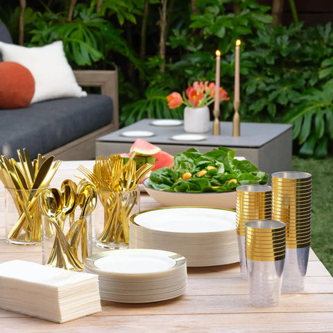 Heavy Duty White Plastic Plates With Gold Trim 175 Piece Bulk Party Essentials arranged on a table with utensils and decor.
