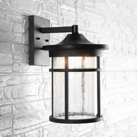 10.25 Inch Black And Clear Outdoor Wall Lantern With Integrated LED on white brick wall, modern farmhouse style