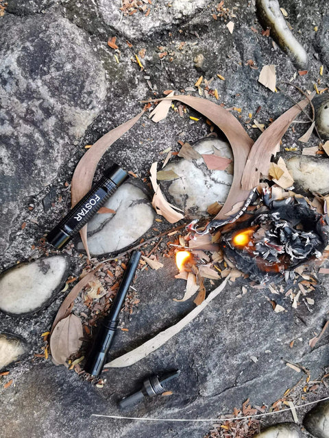 2 Pack Ferro Rod Fire Starter With Replaceable Flint for emergency survival on rocky ground with fire sparks showing usability