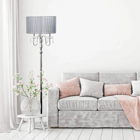 Romantic Cascading Crystal Floor Lamp With Sheer Drum Shade In Chrome Finish, White, beside a modern couch in a light decor room.