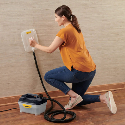 Woman using Chemical Free Wallpaper Steamer For Easy Peasy Removal, No Harsh Chemicals, Dual Steam Plates Included on wall