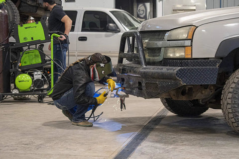 Person welding a truck bumper using Flux Core MIG Wire For Mild Steel E71TGS 0.030 Inch, 2 Pound Spool, indoors