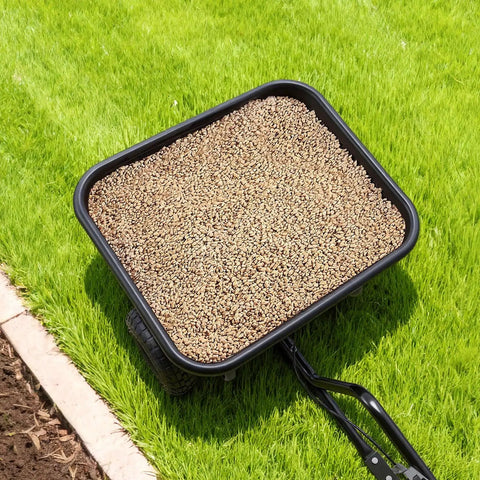 Tow Behind Lawn Spreader For Seed Fertilizer Ice Melt, 9.8 Foot Spreading Width, 85 Lb Hopper, on grassy lawn with seeds