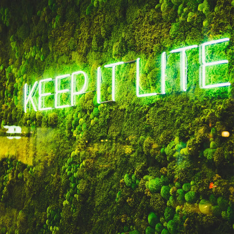 Green LED neon sign on moss wall reading 'KEEP IT LITE', showcasing the LED Neon Flex Strip Lights' vibrant glow.