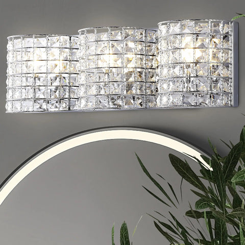 Chrome Modern LED Vanity Light Sconce, 3-Light Glass Crystal Shade above an oval mirror, showcasing glam bathroom lighting.