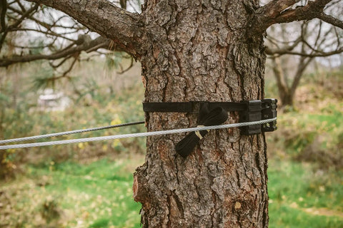 Tree Saver Block Kit For Zip Line Dual Tree Setup With Adjustable Straps on tree, showing nylon blocks protecting bark