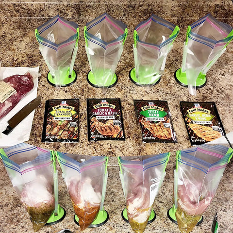 Upgrade Your Kitchen Grind With This Adjustable Ziplock Bag Holder Stand Featuring A Nonslip Base For Effortless Freezer Storage Hands Free Countertop Mount Keeps Plastic Bags Locked Down Straight Up In A Clean Green Set Of Four with marinated meats and seasoning packets.