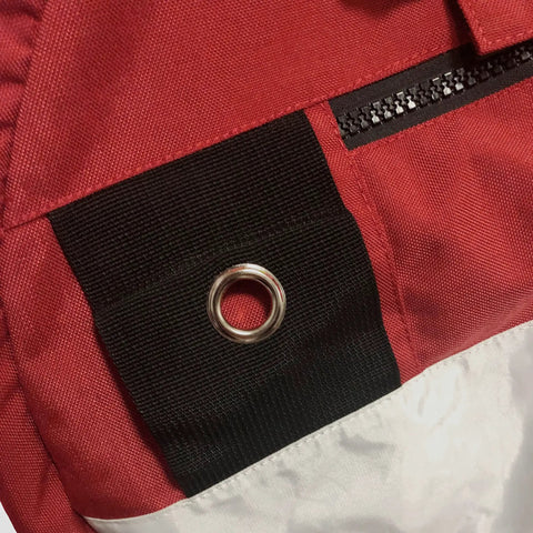 Close-up of red and white Freediving Pro-Grade Buoy With Inner Tube And 8 Inch Dive Flag Cover showing zippered compartment and grommet.