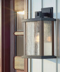 Outdoor Wall Light Sconce In A Sleek Dope Black Finish With Clear Seeded Glass, 17 Inches High By 10 Inches Wide, mounted on wall