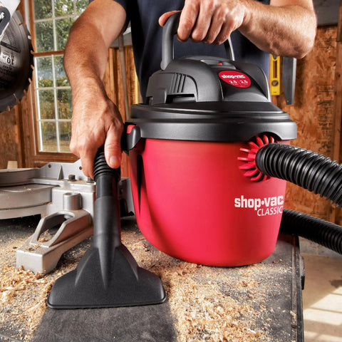 Man using a 2.5 Gallon 2.5 Peak HP Wet Dry Vacuum Portable Compact Shop Vacuum With Collapsible Handle Wall Bracket And Versatile Attachments