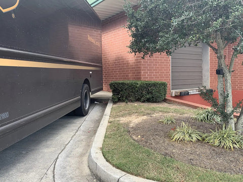 Package delivery truck near a brick building, showcasing delivery scene for Wireless Door Alarm Kit With 4000 Ft Range 120 dB Siren.
