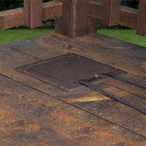 DOC320Z Outdoor Deck Power Cover 1-Gang Bronze With Low Profile Beveled Edge on a wooden deck, two cords visible.