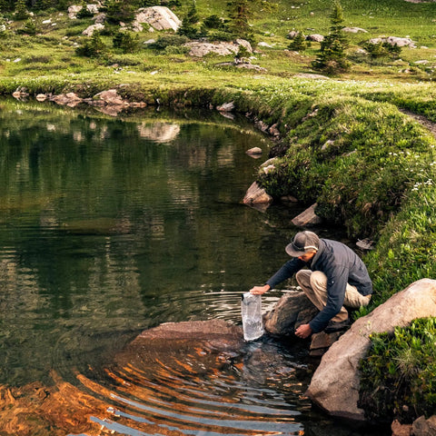 Man using Replacement 6.0 Liter Water Reservoir Kit For GravityWorks System by a scenic riverside