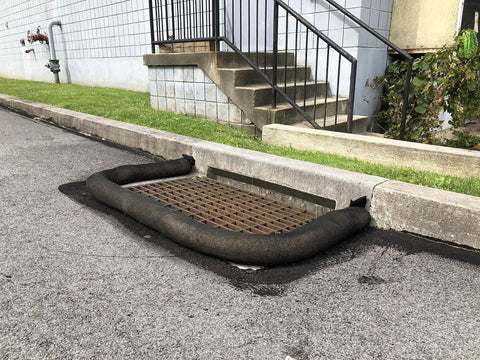 Sediment Filter Sock for Erosion Control and Storm Drain Protection, 5-inch diameter by 10-foot long, black, around street drain.