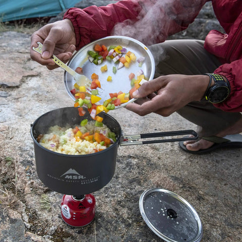 2.5 Liter Nonstick Ceramic Camp Pot For Solo Cooking With Fusion Ceramic Coating in use outdoors, stirring ingredients