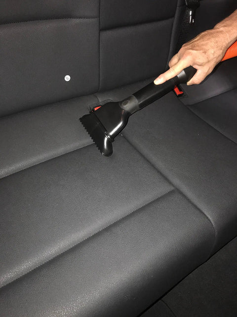 Person using Shop Vacuum Garage Kit with 30 Foot Commercial Grade Hose on car seat for non clog airflow and high flexibility.