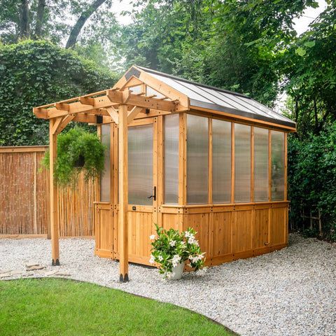 Outdoor view of Bellerose Walk In Greenhouse Kit with cedar wood frame, polycarbonate panels, and pergola cover.